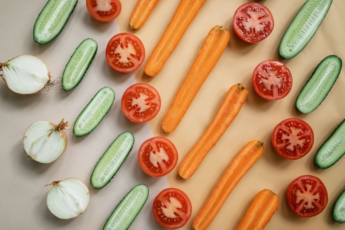 Tomatoes, carrots, cucumbers and onions laid out in neat rows