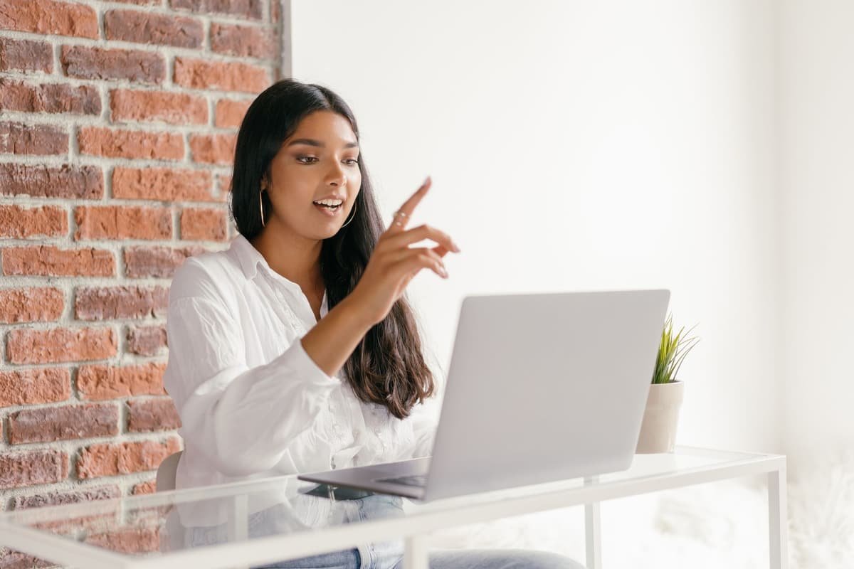 A young Indian woman talking to her doctor on a laptop video call