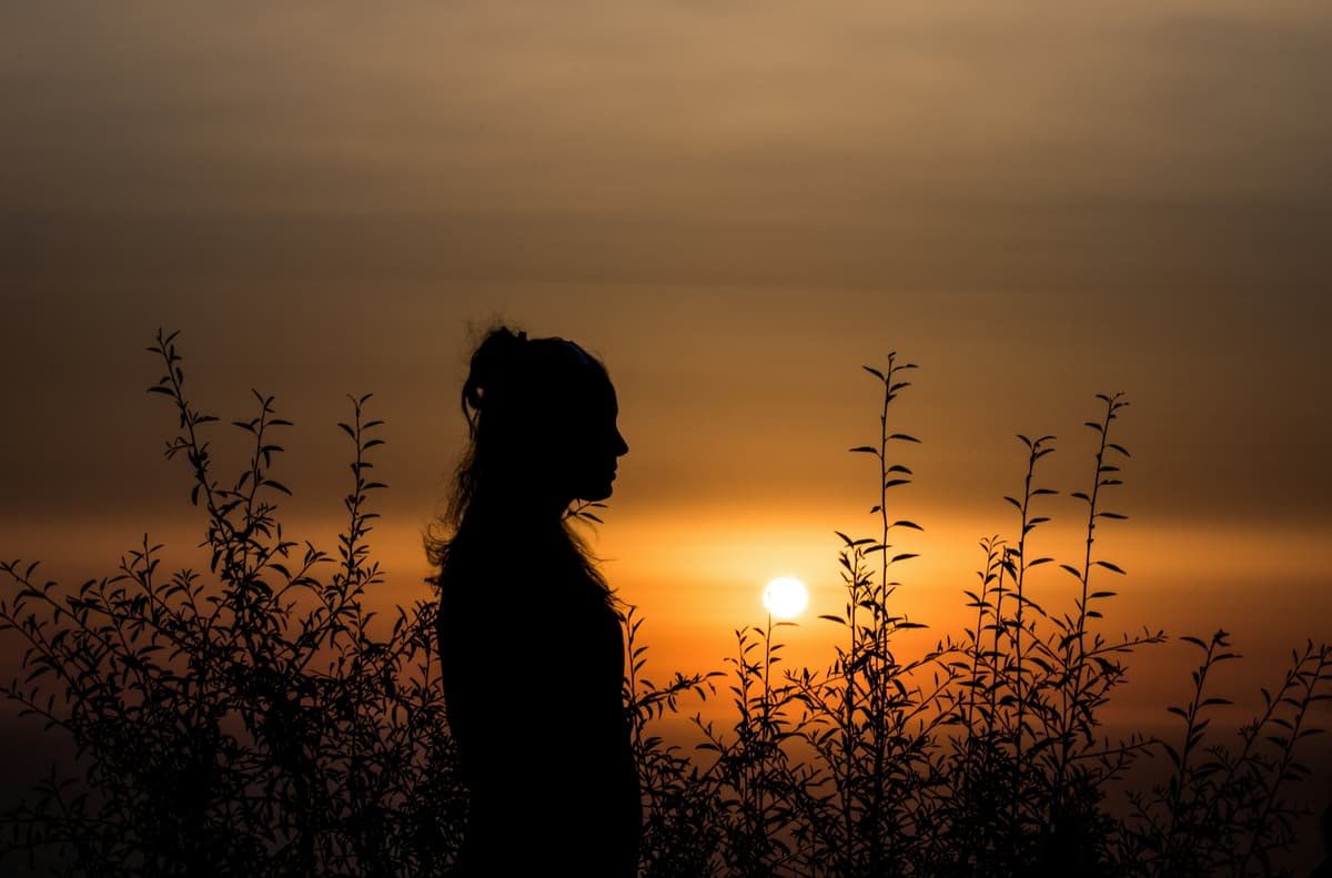 A woman's silhouette against the setting sun