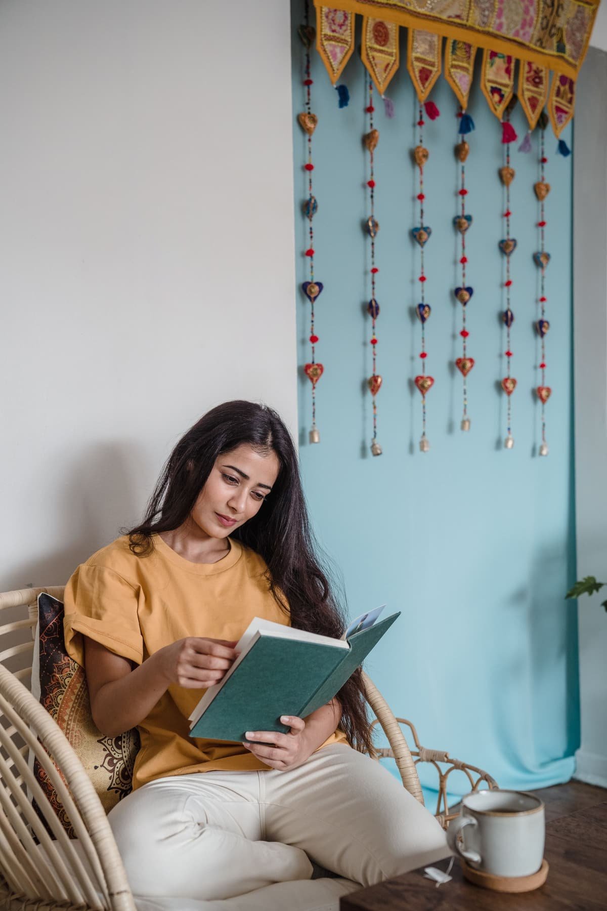 A young woman reading a book at home